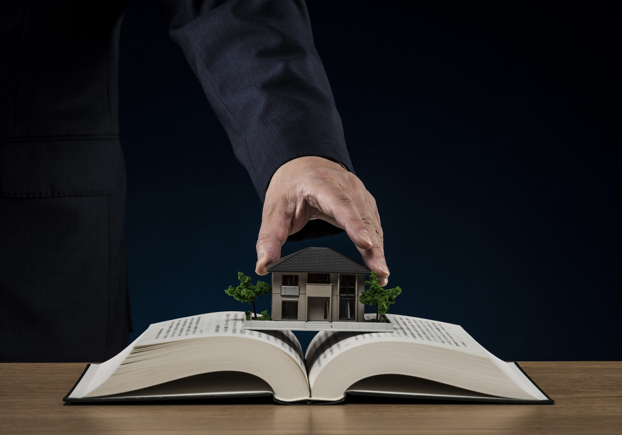Businessman with open book and house model